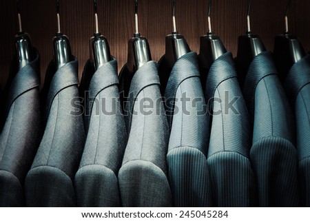 Row of men suit jackets on hangers Royalty-Free Stock Photo #245045284