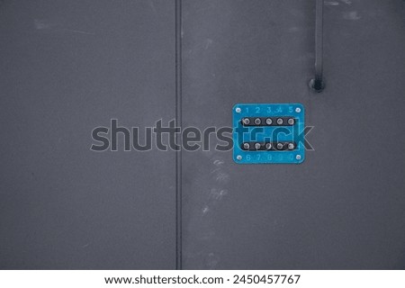 A blue combination lock on the black entrance door