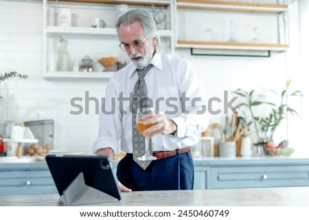 Mature executive enjoys a moment of contemplation with a beverage in a stylish kitchen setting.
