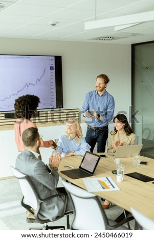 Multiethnic group of professionals brainstorming around a conference table in a brightly lit office. Royalty-Free Stock Photo #2450466019