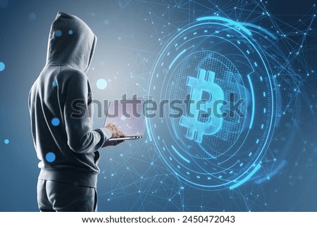 Side view of hacker holding laptop with creative round money sign on blurry blue polygonal background. Crypto, hacking, online banking, digital transformation and finance concept
