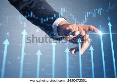 Close up of businessman hand pointing at growing blue vertical arrows and candlestick forex chart on blurry index grid background. Economic growth and increase concept. Double exposure