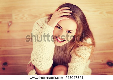 Picture of a careless young caucasian woman on the wooden floor.
