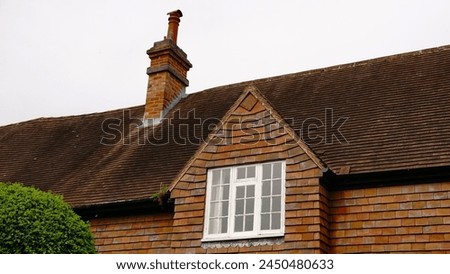 Low angle of Anglo-Saxon style house roof against sky Royalty-Free Stock Photo #2450480633