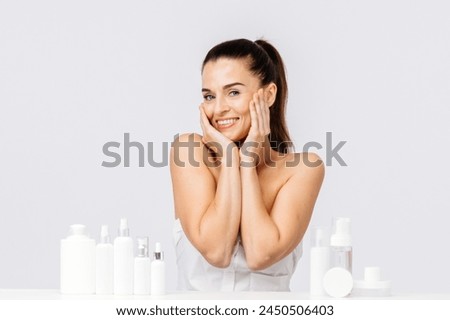 Gorgeous middle aged woman touching her perfect skin. Beautiful portrait of a 40-50 year old woman advertising anti-aging facial products, salon care, skin tightening, isolated on white background. Royalty-Free Stock Photo #2450506403