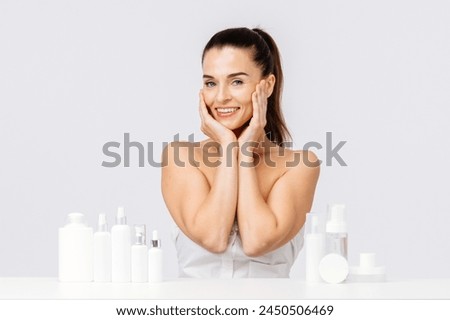 Gorgeous middle aged woman touching her perfect skin. Beautiful portrait of a 40-50 year old woman advertising anti-aging facial products, salon care, skin tightening, isolated on white background. Royalty-Free Stock Photo #2450506469