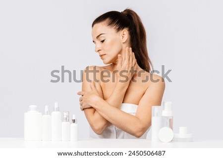 Gorgeous middle aged woman touching her perfect skin. Beautiful portrait of a 40-50 year old woman advertising anti-aging facial products, salon care, skin tightening, isolated on white background. Royalty-Free Stock Photo #2450506487