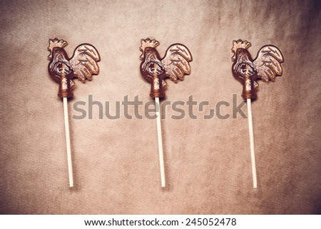 sugar lollipop roosters on wooden paper edited