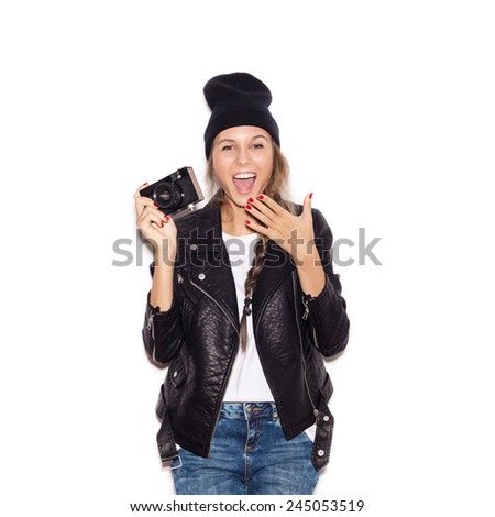 Happy hipster girl in black beanie having fun with vintage noname camera. Laughing young woman. White background, not isolated