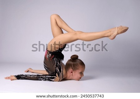 Portrait of a rhythmic gymnastics artist on a white background. Young beautiful sportive girl.