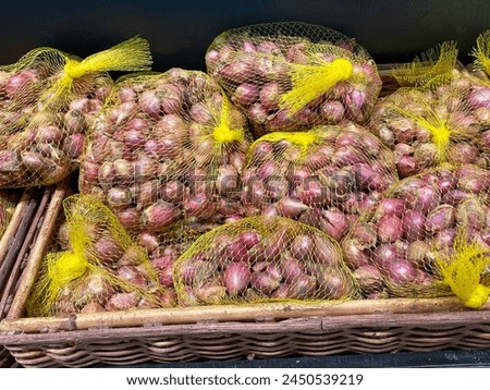 Dried onions in a white mesh bag ready for sale.