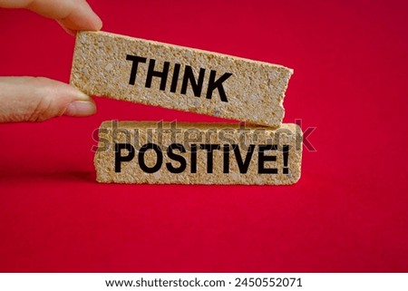 Think positive symbol. Concept words Think positive on beautiful brick blocks. Beautiful red background. Businessman hand. Business, motivational think positive thinking concept. Royalty-Free Stock Photo #2450552071