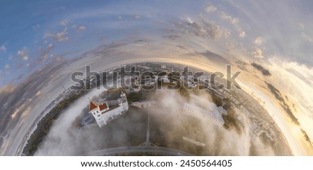 Aerial view from high altitude tiny planet in sky with clouds overlooking old town, urban development, buildings and crossroads. Transformation of spherical 360 panorama in abstract aerial view. Royalty-Free Stock Photo #2450564405