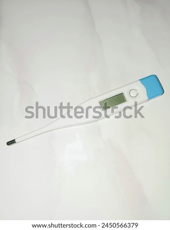 Electronic body thermometer that displays a healthy human body temperature of 32.2 degrees C (Celsius). Isolated on white background. Royalty-Free Stock Photo #2450566379