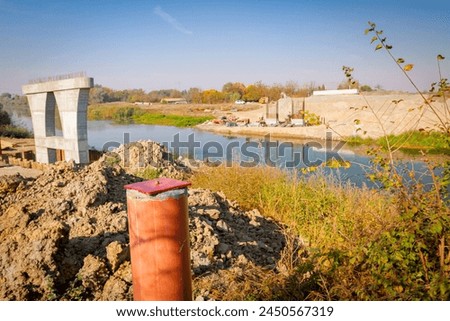 Red metal pole, side device, for determine level of bridge, 4 points for determining exact dimensions and check elevations. Construction of the bridge is in progress. Royalty-Free Stock Photo #2450567319