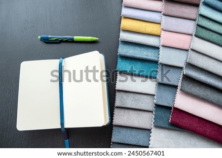 Fabric rainbow color swatch book fabric textile with pen and empty notebook copybook. Material for repair furniture 