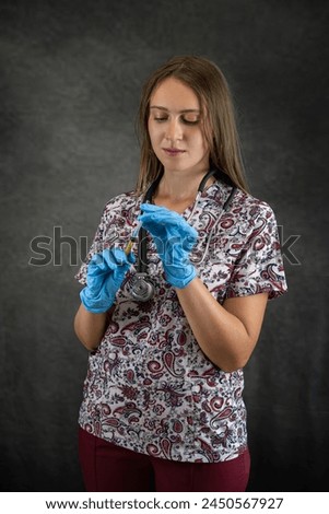 Caucasian young nurse wear uniform gloves holding syringe with a vaccine. Health care concept