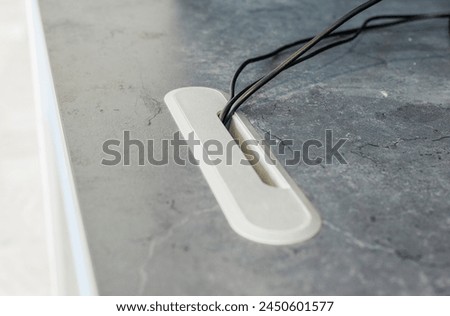 Fragment of a table in an office with wires going down from the mouse and keyboard