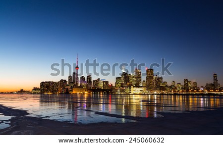 The Toronto Skyline in the Winter from the East at sunset showing the frozen lake and patches of snow on the ice