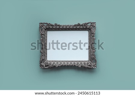 Vintage silver picture frame on pastel blue background.; openwork metal frame, empty picture frame mockup