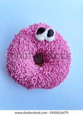 pink donut with eyes on a blue background