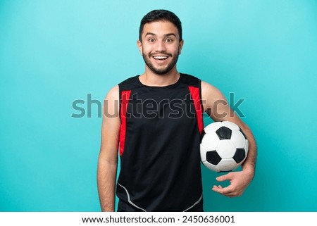 Young football player Brazilian man isolated on blue background with surprise facial expression