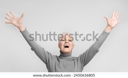 Senior european woman with mouth open and arms raised, a perfect visual for expressing excitement Royalty-Free Stock Photo #2450636805