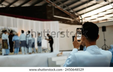 Guest taking pictures of brides at Malay Wedding.