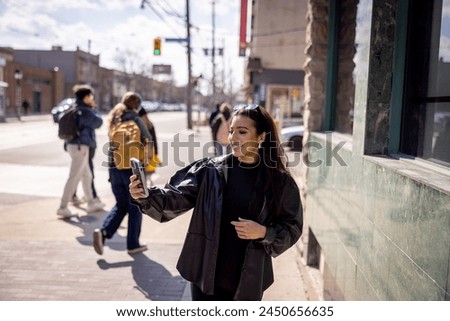 Young woman taking selfie in the city with smart phone