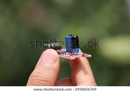 Flame sensor that detects the fire used in making prototype micro controller and breadboard projects held in the hand Royalty-Free Stock Photo #2450656769