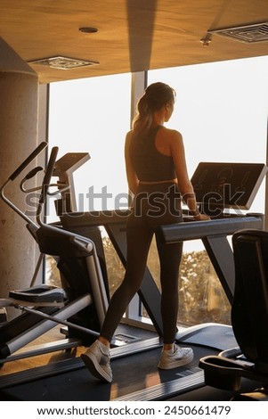 Here is the translation to English:

"In the photograph, an exercise scene: dumbbells, exercise machines, a girl working out