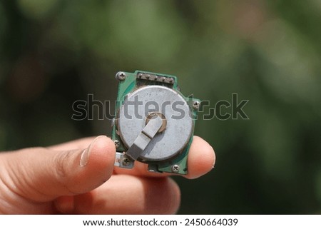 Old brushless dc motor held in the hand. Dc motor found in small electronic devices like printers Royalty-Free Stock Photo #2450664039