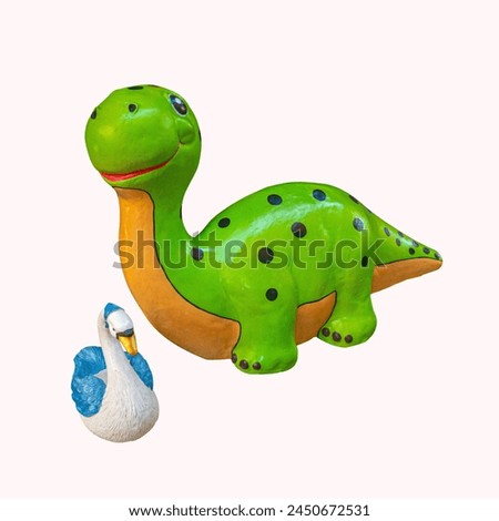  large green dinosaur toy adorned with blue spots and an orange underbelly.  friendly expression, featuring big eyes and a wide smile. Beside the dinosaur, we see a smaller white swan figure with blue