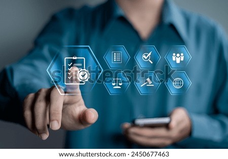 Compliance in business concept. Stay in line with business policies. Businessman touching compliance icon on virtual screen, ensuring the enforcement of laws, regulations, and standards.  Royalty-Free Stock Photo #2450677463