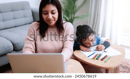 Business Asian mother work with child painting at home. Family love concept Royalty-Free Stock Photo #2450678619