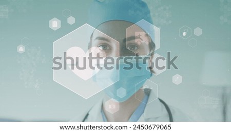 Image of medical icons over caucasian female doctor wearing face mask. global medicine, healthcare and technology during covid 19 pandemic concept digitally generated image.
