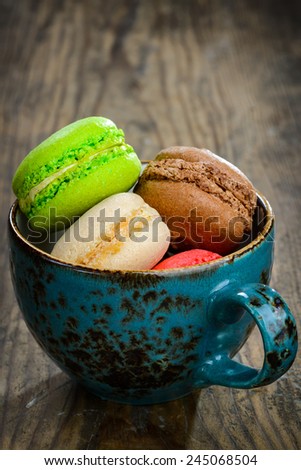 Sweet and colourful french macaroons on wooden background
