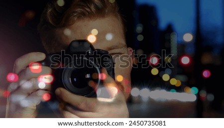 Caucasian male photographer clicking pictures with digital camera against night city traffic. world photo day awareness concept