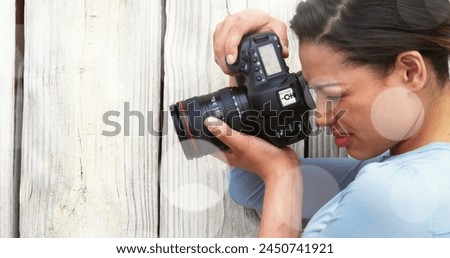 White spots against close up of caucasian female photographer clicking pictures with digital camera. world photo day awareness concept