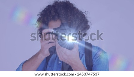 Spot of light against african american male photographer clicking pictures with digital camera. world photo day awareness concept