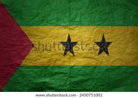 colorful big national flag of sao tome and principe on a grunge old paper texture background Royalty-Free Stock Photo #2450751001