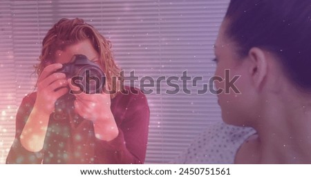 Glowing spots against caucasian male photographer clicking pictures of female model outdoors. world photo day awareness concept