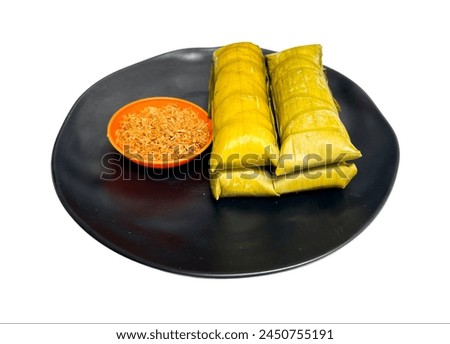 Burasa or Buras is an Indonesian rice dumpling from South Sulawesi, cooked with coconut milk packed inside a banana leaf pouch Royalty-Free Stock Photo #2450755191