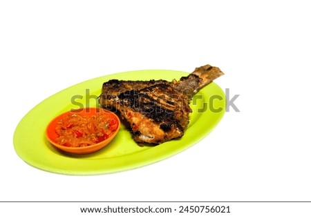 grilled fish and chili sauce on a plate isolated on white background