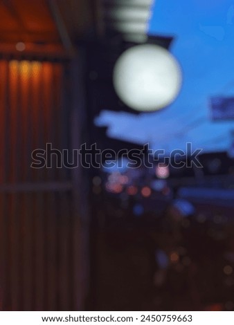 Abstract dark blurred bokeh light in front of modern cafe restaurant with empty blank circle signboard. 