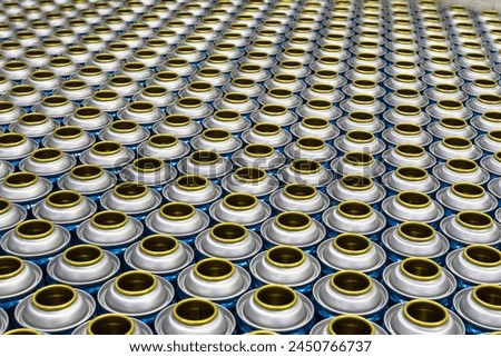 Cans, group of many empty valveless aerosol cans in manufacturing process, aerosol manufacturing Royalty-Free Stock Photo #2450766737