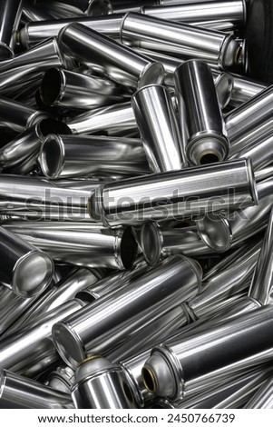 Cans, group of many empty valveless aerosol cans in manufacturing process, aerosol manufacturing Royalty-Free Stock Photo #2450766739