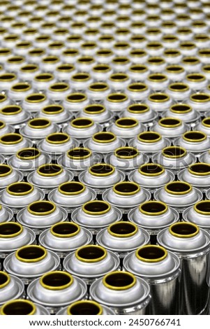Cans, group of many empty valveless aerosol cans in manufacturing process, aerosol manufacturing Royalty-Free Stock Photo #2450766741