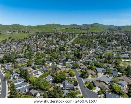 Drone photos over the landscape of Clayton, California with blue skies and green hills.