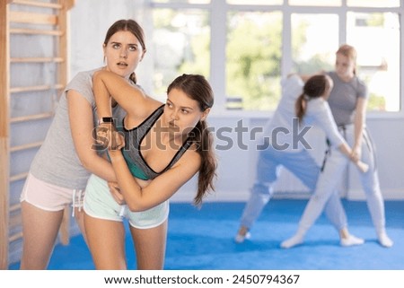 Two teenage girls training in group self-defense classes